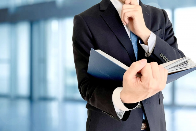 資料を読み特定技能制度について学んでいる男性社員