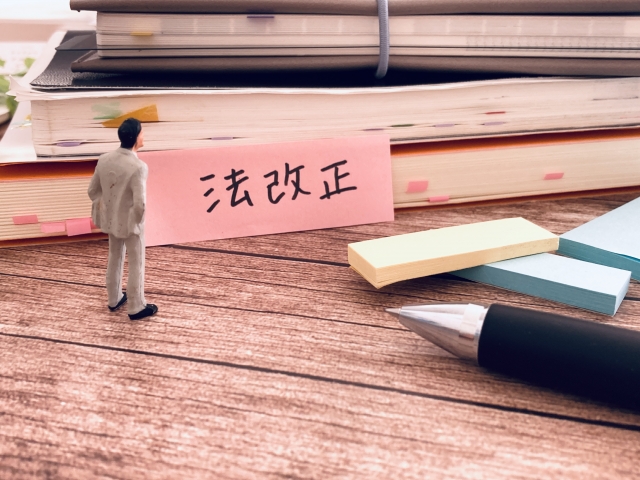 書類とペン 積み上げれれた書類と法改正と書かれた付箋