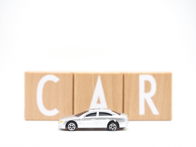 CARと書かれた木の風呂奥の前に置かれたミニチュアの白いセダン