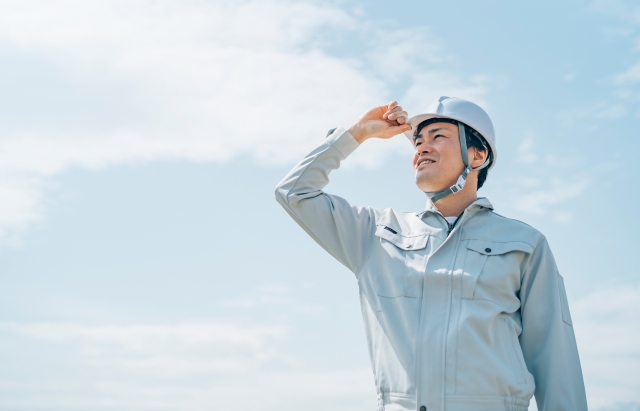ヘルメットと作業服を着た男性
