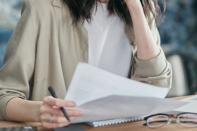 書類作成 申請書類を準備している女性従業員
