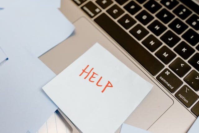 支援 HELPと書かれた付箋が貼ってあるパソコン