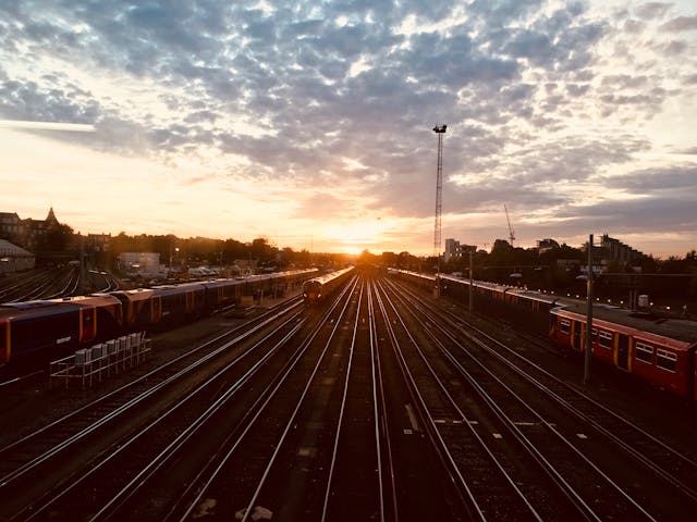 夕焼け空をバックに走行する鉄道列車