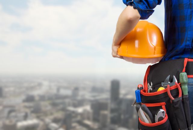 ヘルメットと道具を持っている建設現場の作業員