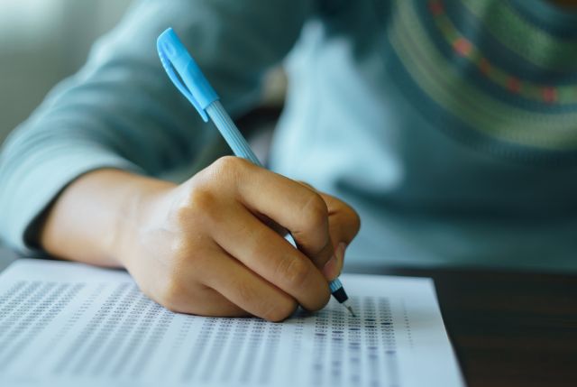 特定技能試験 評価試験のマークシート用紙に回答を記入している外国人