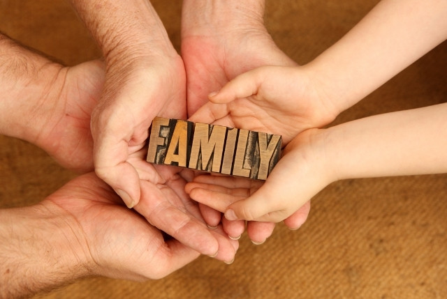 FAMILYの文字を支えあって持っている家族の手