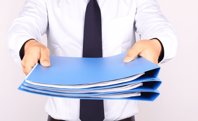 更新手続きに必要な書類を提出している男性社員