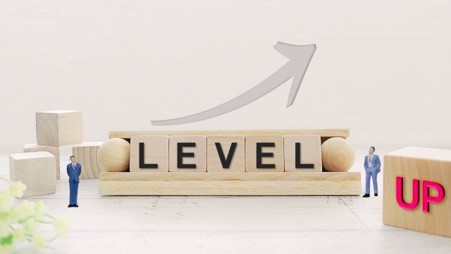 LEVEL UPの文字とミニチュアのビジネスマン