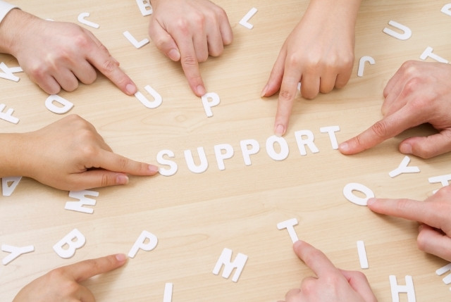 支援体制 中央に置かれたSUPPORTの文字を指さしている手