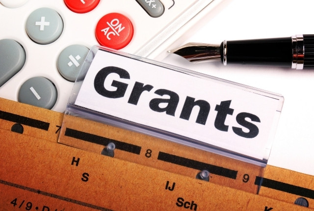 “Grants”と表示されたフォルダーの見出しラベルと、近くに置かれた電卓とペン