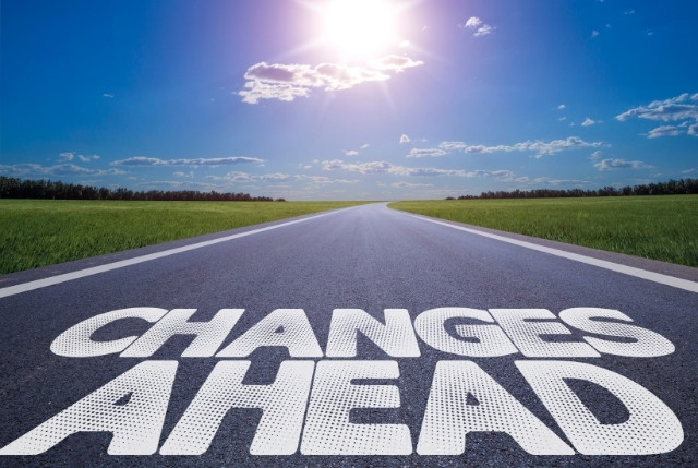 青空の下、まっすぐに続く道路に「CHANGES AHEAD（変化が待っている）」と大きく描かれた風景。外国人雇用や採用制度の変化を示すイメージ。
