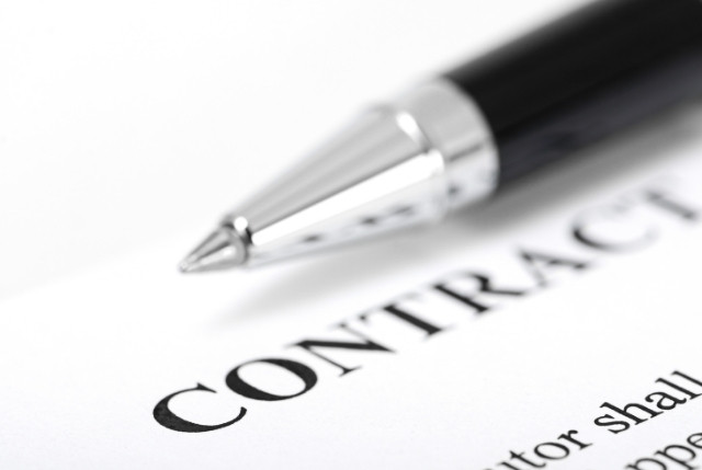 黒いペンと『CONTRACT』と印字された契約書。ビジネス契約や合意締結を象徴するイメージ。